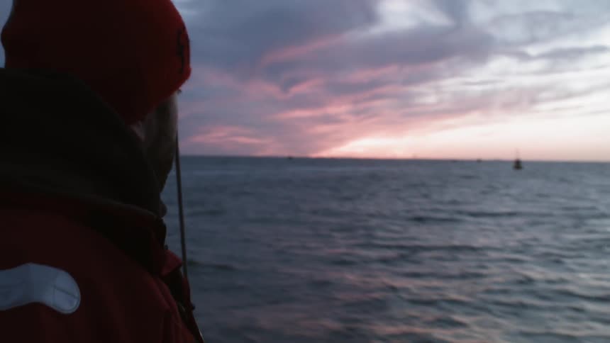 A man on a boat looks out at the water