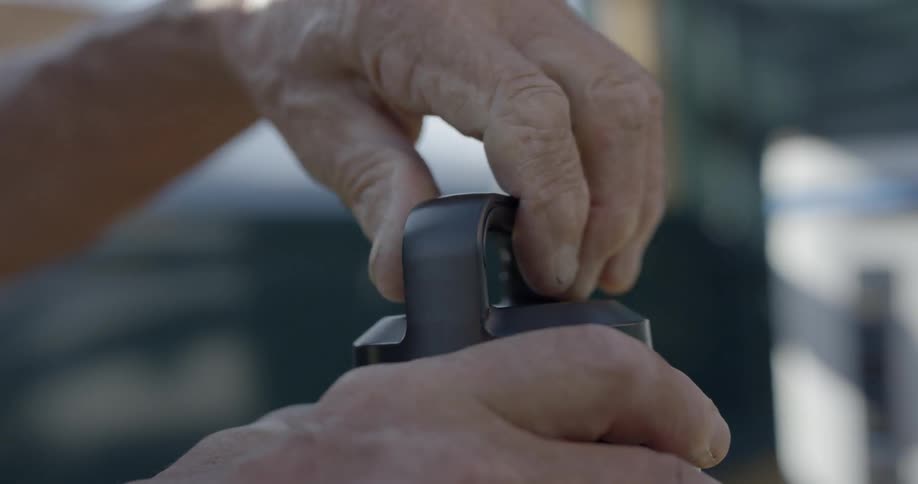 A man spins the top of a bottle to open it