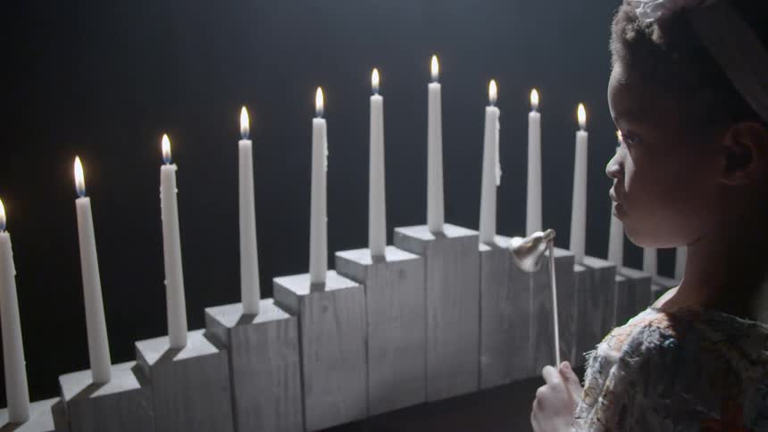 Girl watching rows of candles