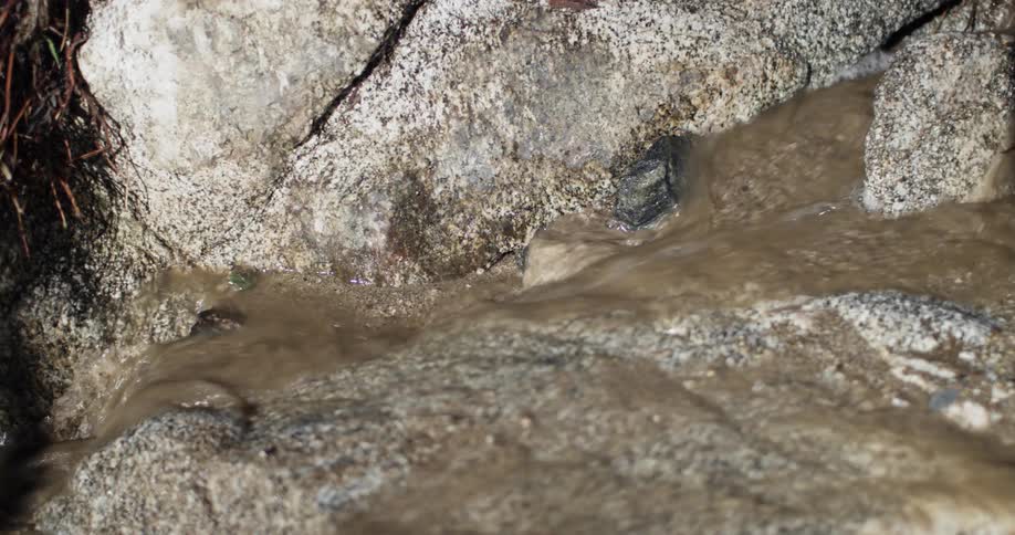 Tight shot of water flowing between rocks