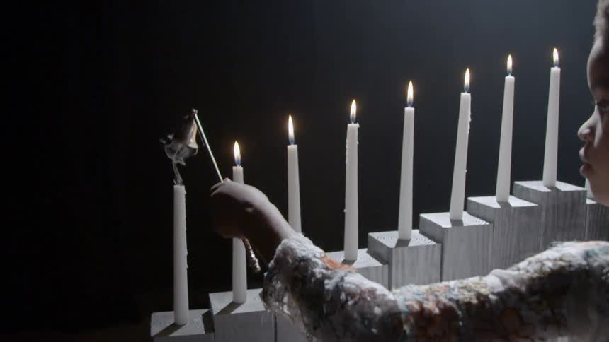 A child is lighting candles indoors