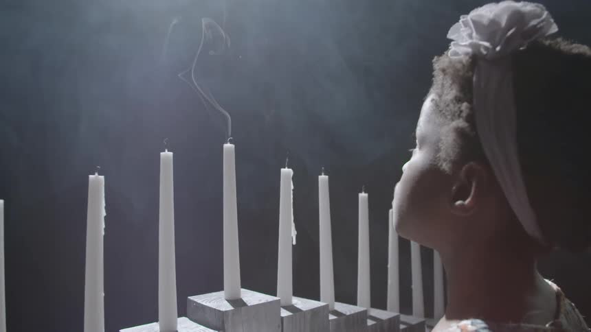 Child looking at the smoke from the candle