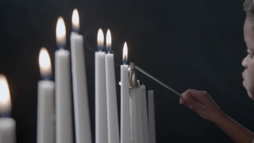 A child extinguishes a candle