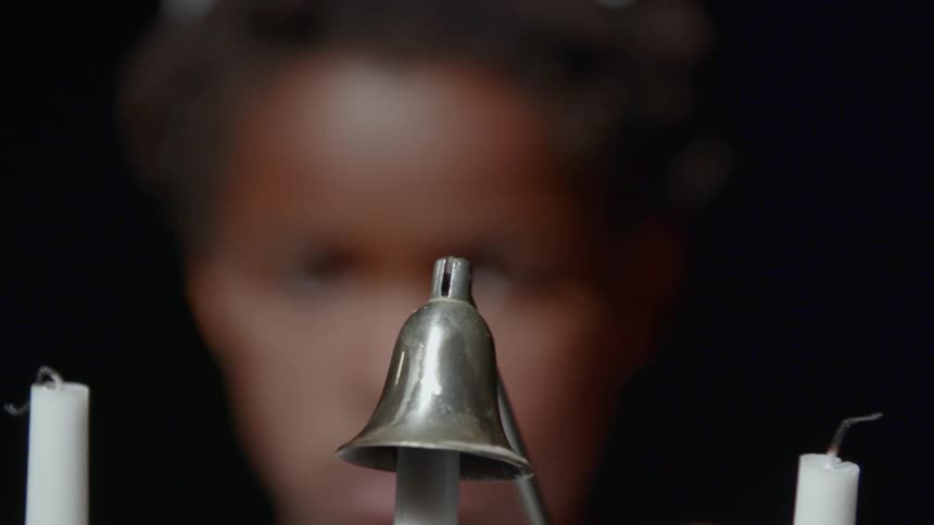 A child uses a candle snuffer to extinguish a candle