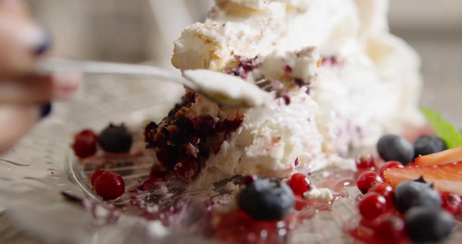 A person is picking up a piece of dessert with a spoon