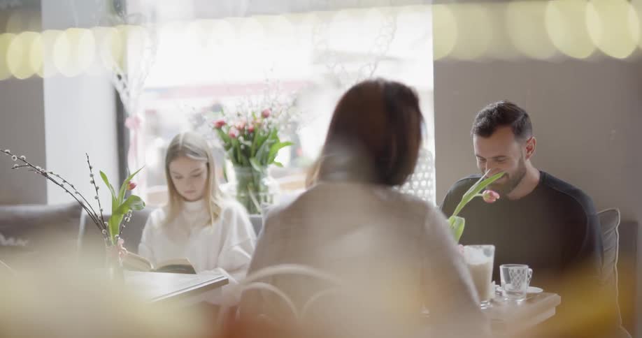People sit together at a table with flowers