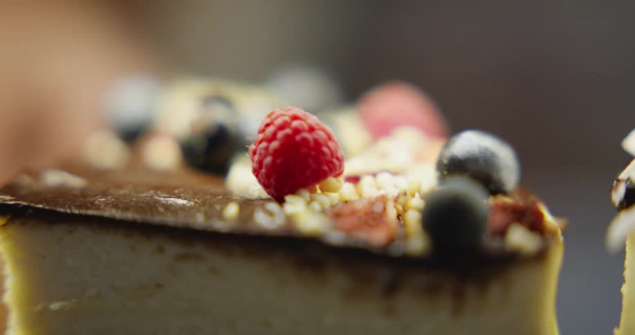 A piece of dessert topped with fruit is pulled away