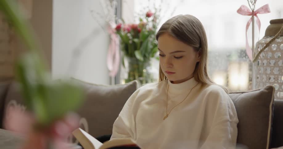 A woman is reading a book indoors