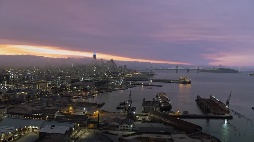 Lights glow in a city waterfront at sunset