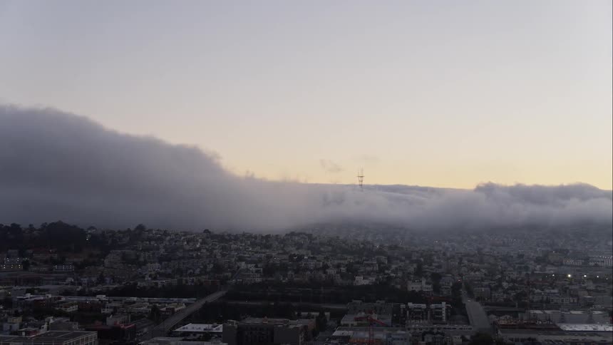 Clouds float over city buildings at dawn