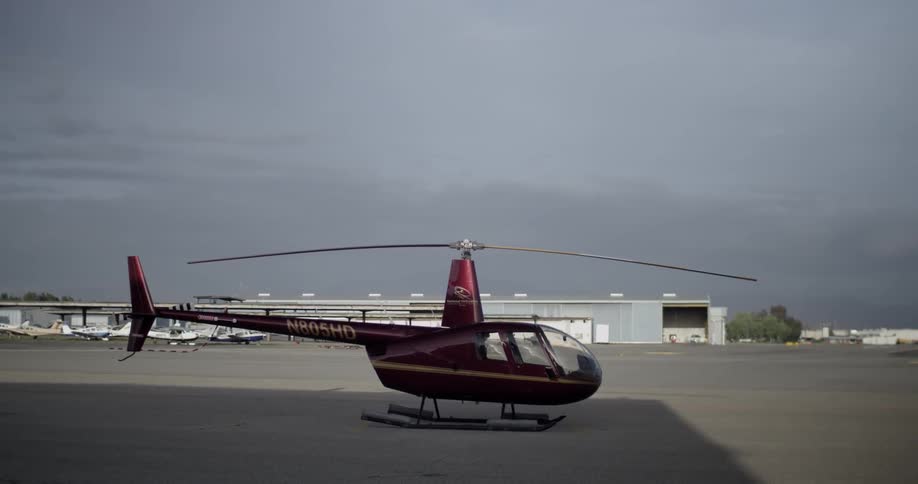 A helicopter sits on an airport tarmac