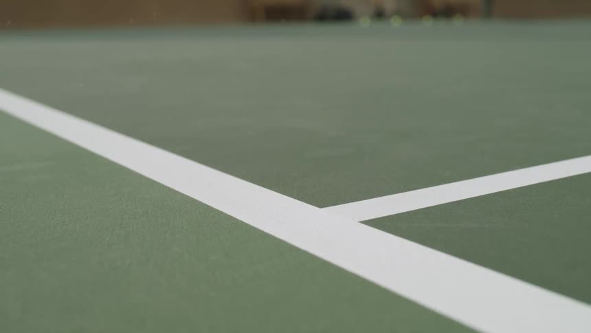Tennis ball hits court surface just inside line