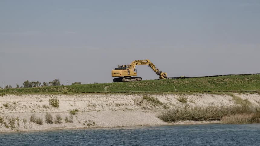 An excavator is clearing items from a work site