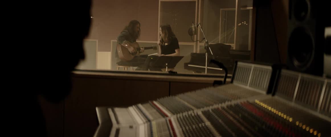 Singer and guitarist recording in a music studio