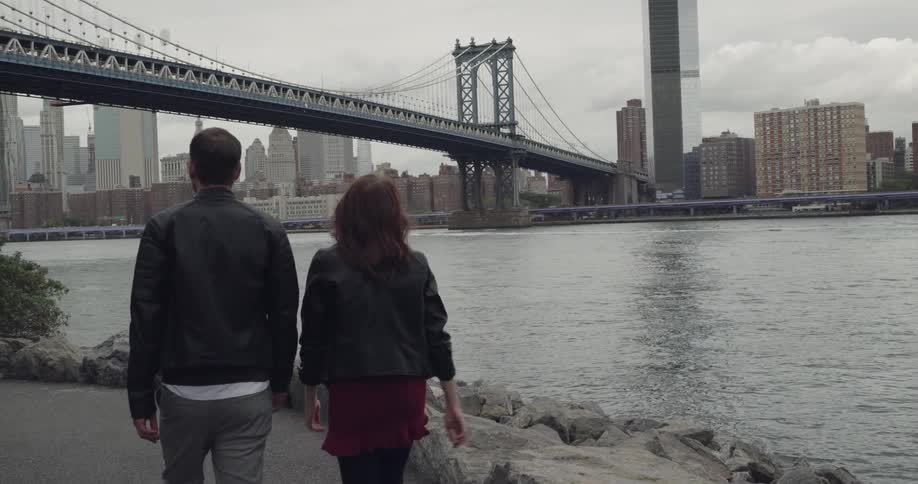 A couple walks toward the bridge