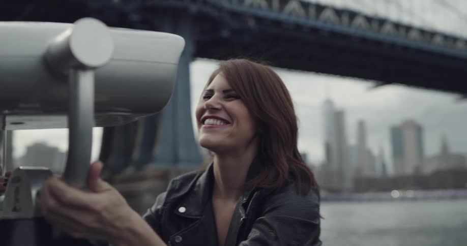 Couple having fun while looking through a viewfinder in the city