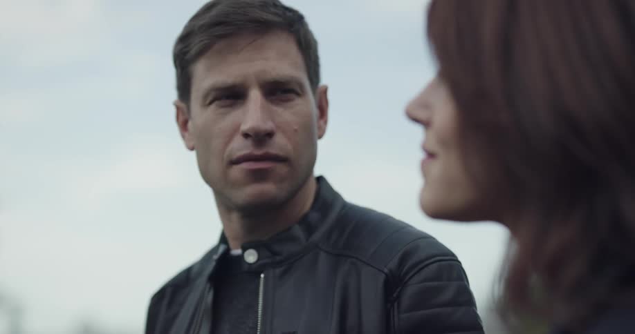 A man and woman looking off before looking at each other