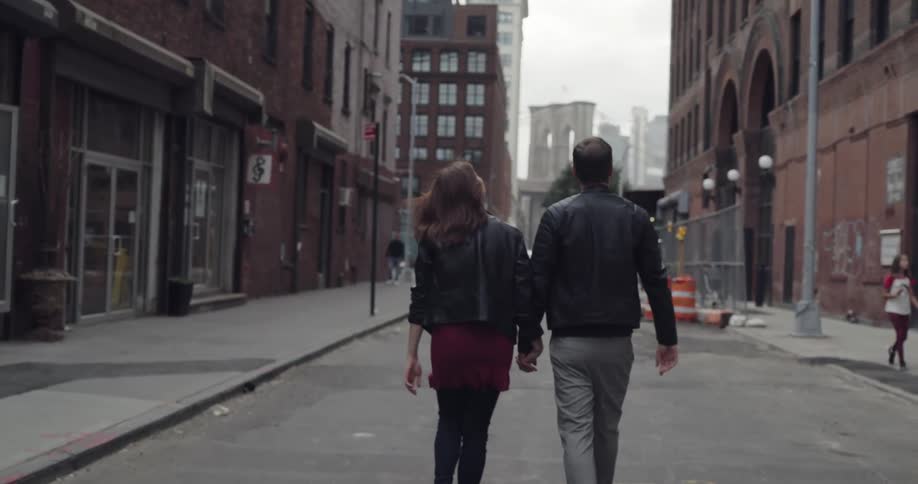 Man and woman walking down the middle of the street