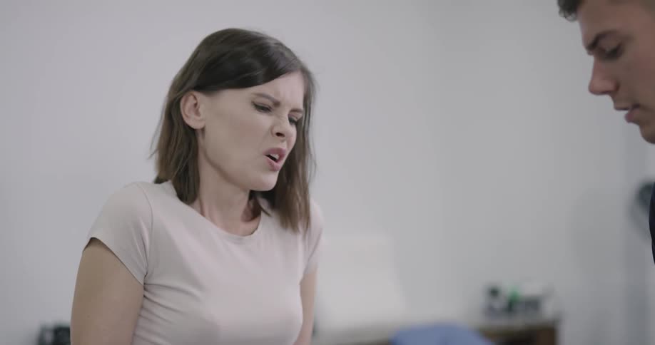 Man adjusts leg brace and woman winces