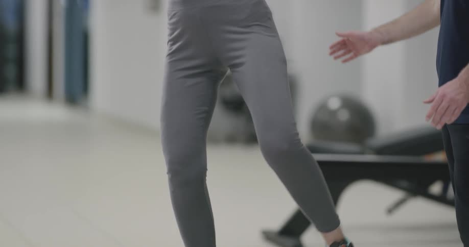 A young woman balances on a bosu ball