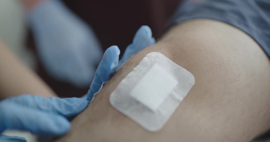 A nurse places bandages on a patients arm