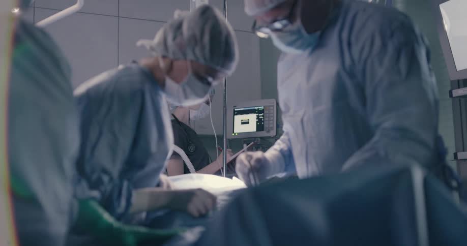 Surgical team works on patient in operating room