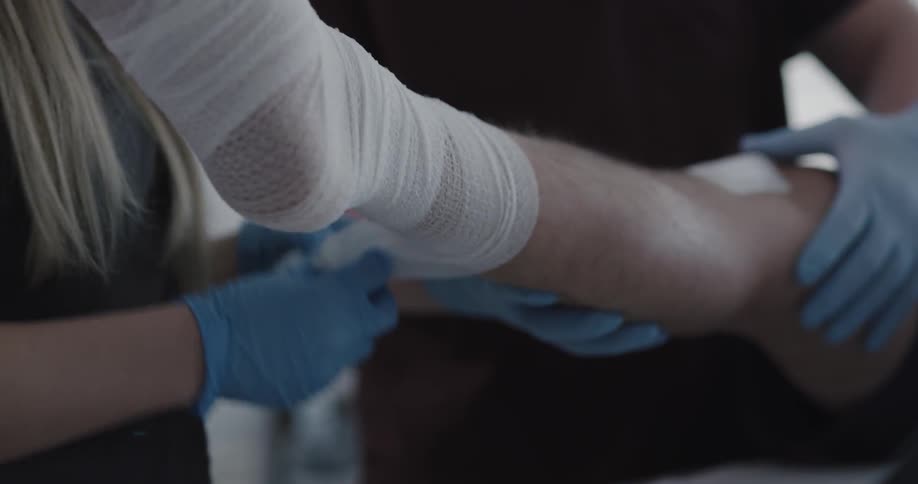 Female nurse unwrapping a bandage from a patients ankle