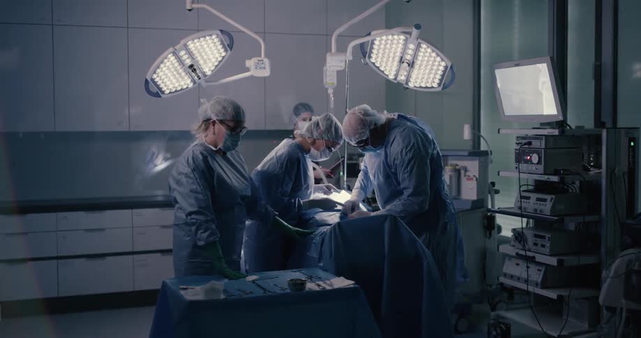 A surgical team approaching the operating table to perform an operation