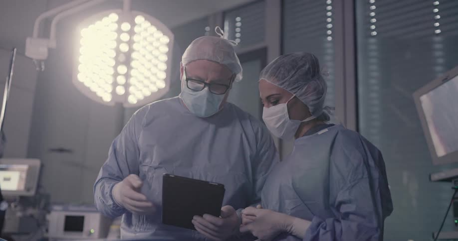 Doctors looking at a tablet in a or