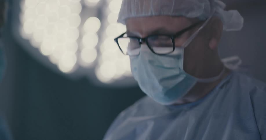 A doctor talks with others in an operating room