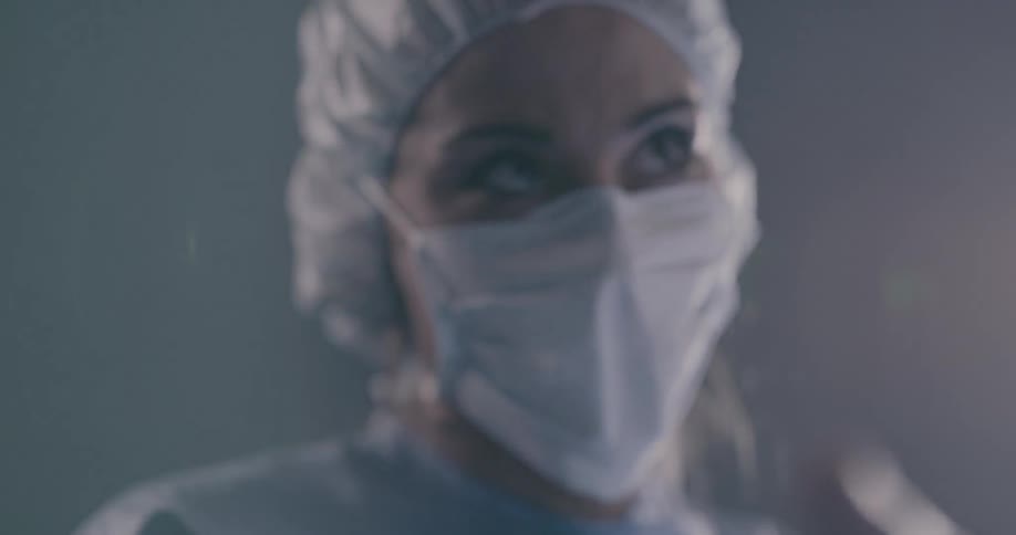 Two surgeons are looking down at a patient