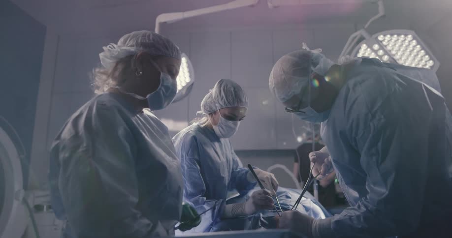 Doctors and nurses perform surgery on a patient in a surgical room