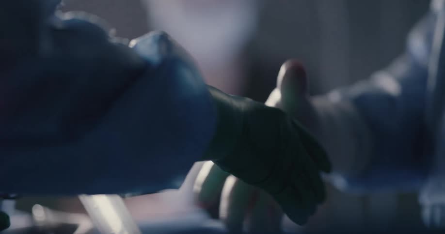 A nurse uses a syringe during surgery