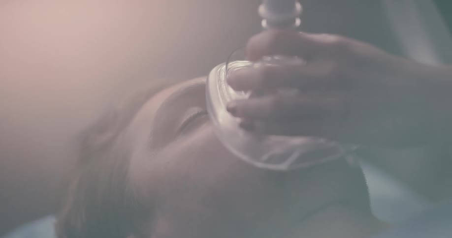 Woman applies an oxygen mask over a mans face