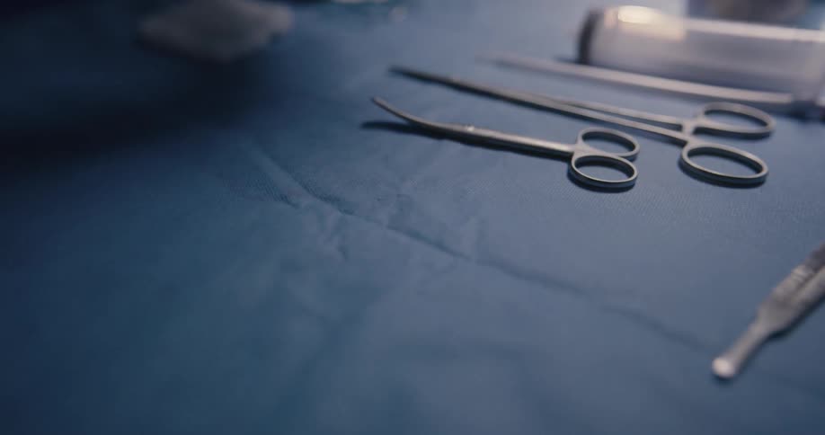 Surgeon arranging surgical instruments on operating table