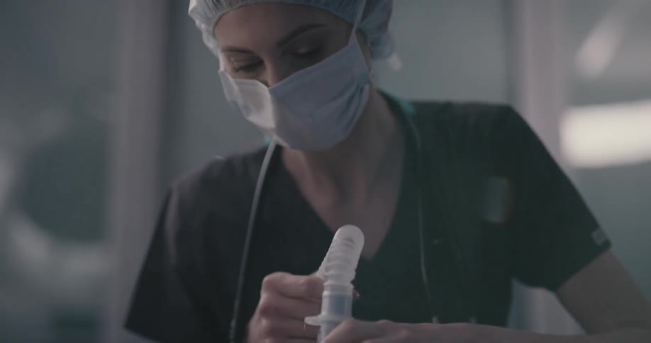 An unconscious man being installed a breath device by a doctor