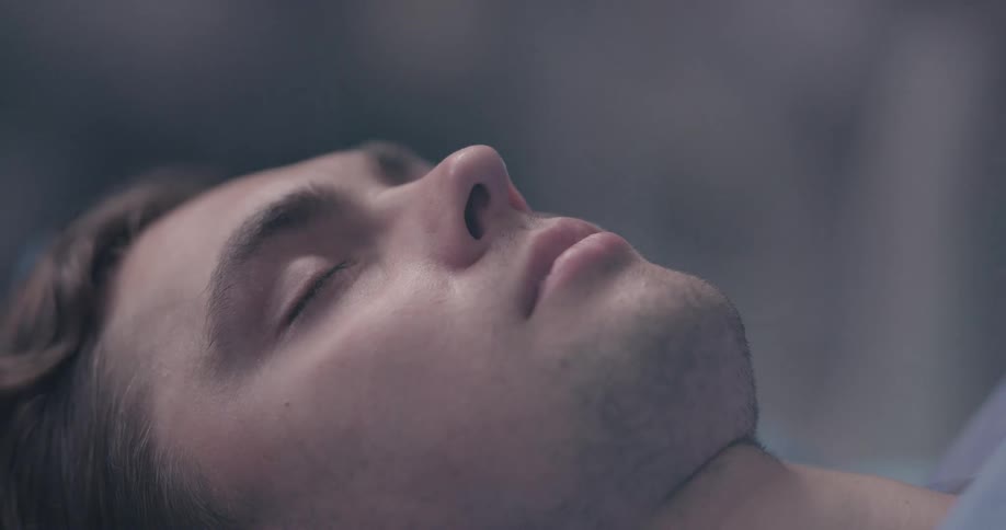 A patient lies on a table as a mask is put over his mouth