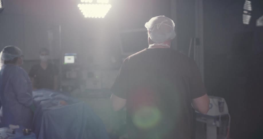 A surgeon walks over to the operating table