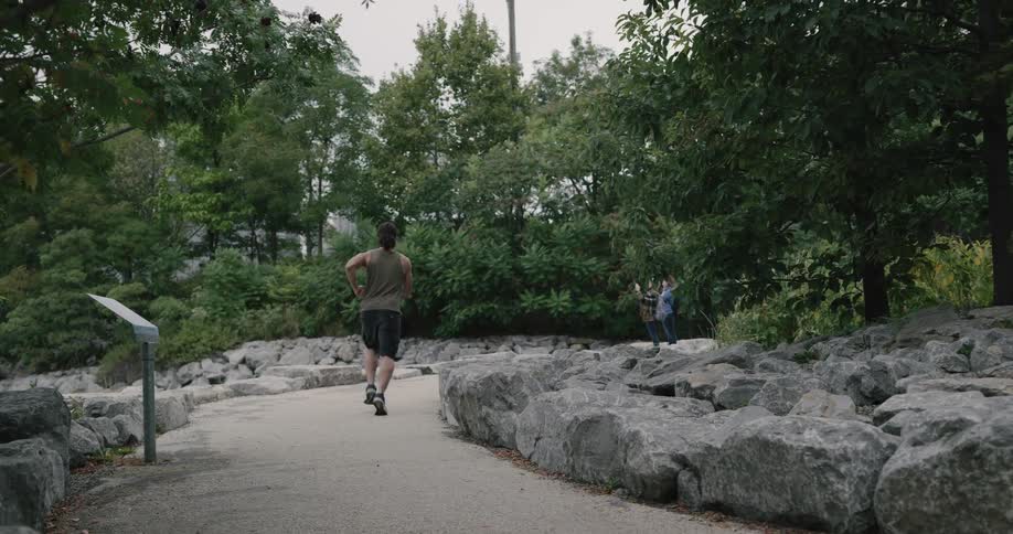 A man is jogging through the park