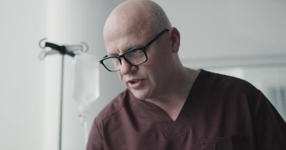 Nurse talks while standing next to iv in patients room