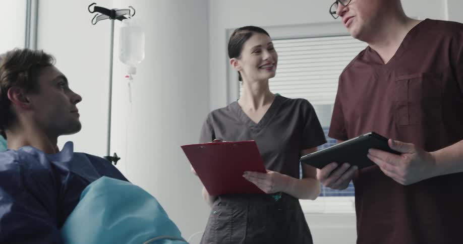 Male doctor and nurse explain something to the patient