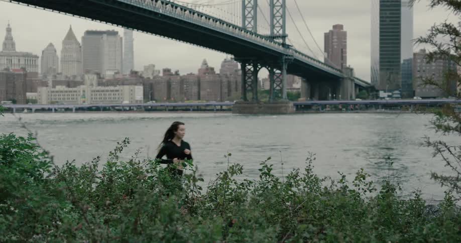 Young woman running on the track under the bridge