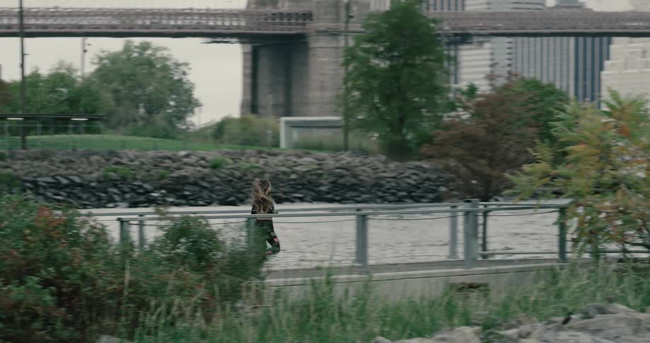 Young woman running on the public park near brooklyn bridge at the morning