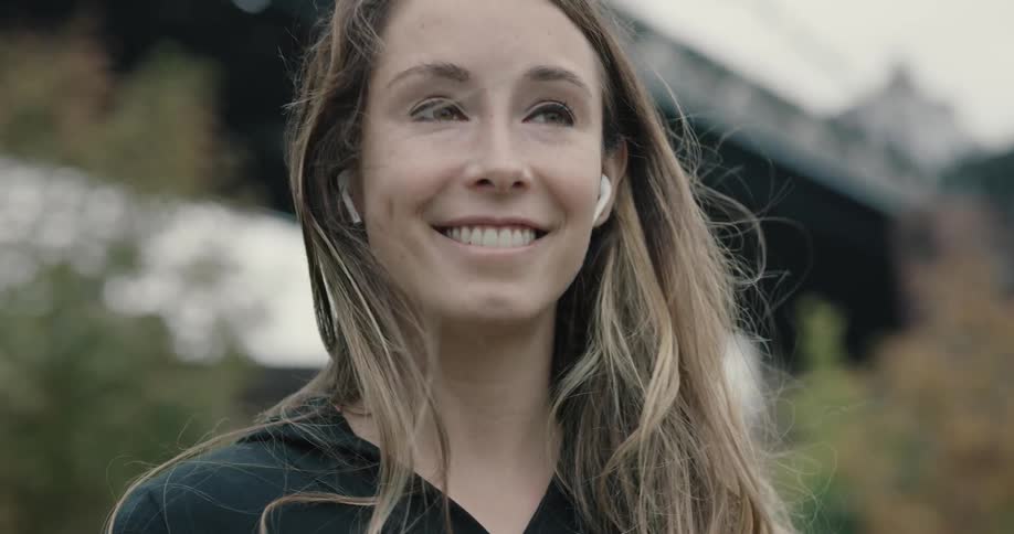 A woman is smiling outdoors