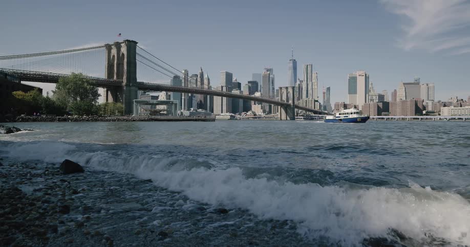 Waves hitting the river bank under brooklyn bridge