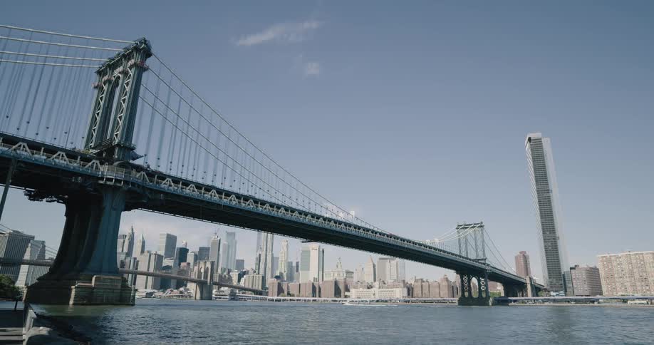 Skyline of the city with tall buildings and bridge next to the sea during daylight