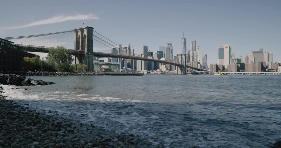 A view of brooklyn bridge on a clear day from the river bank