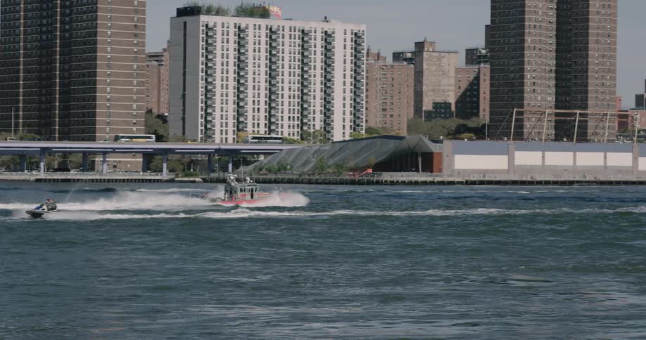People sail on the boat at the river near a city