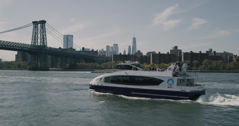 A boat drives through a lake with the city in the background