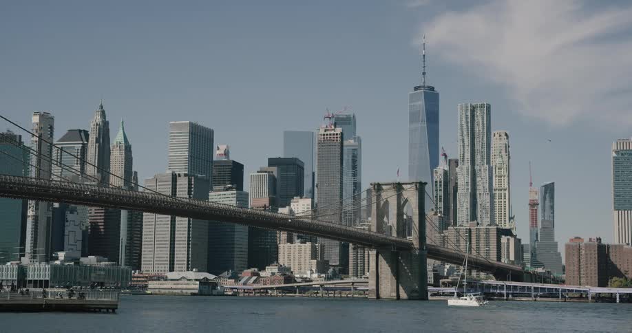 A bridge extending over a bay from a large metropolis